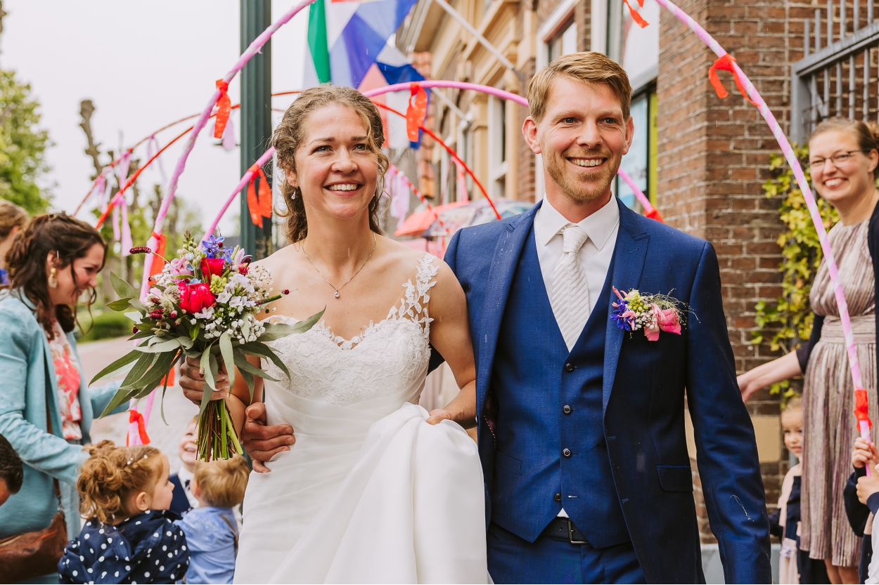 Onder slingers en vlaggetjes de kerk uit
