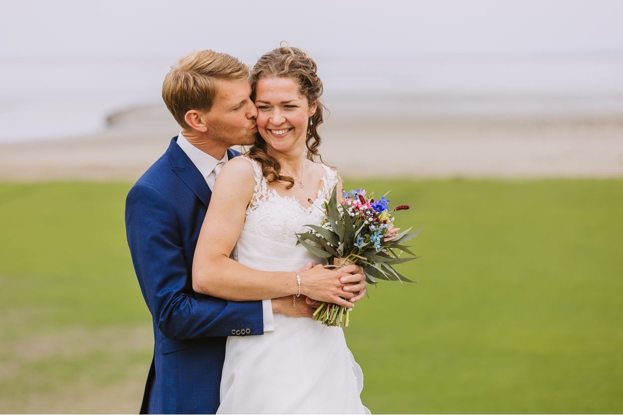 Marije en Sietse op de zeedijk met de Waddenzee op de achtergrond