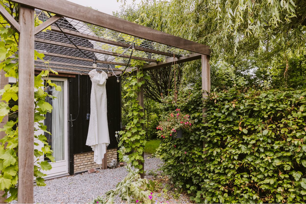 Ceremonie onder een groene pergola bij Sneek